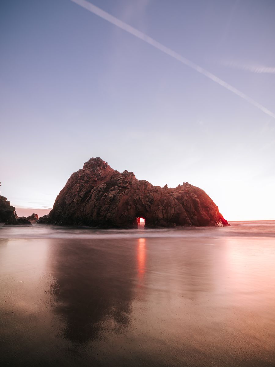 O arco de pedra de Pfeiffer Beach ao entardecer, em Big Sur