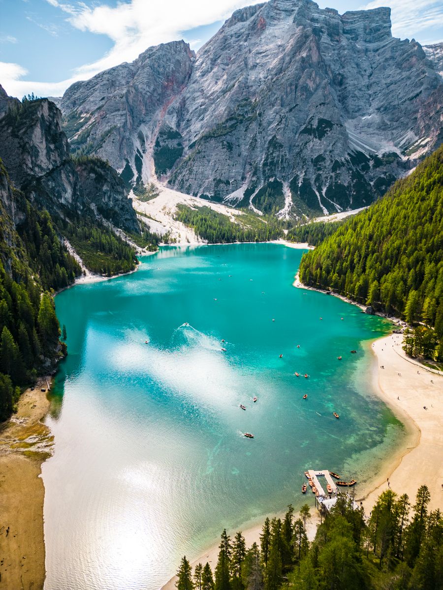 O Lago di Braies, verde-azulado, visto do alto entre montanhas e pinheiros