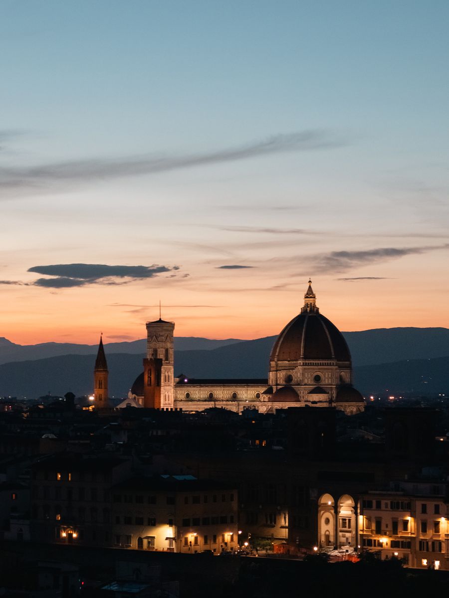O Duomo de Florença iluminado ao anoitecer, com as colinas da Toscana atrás