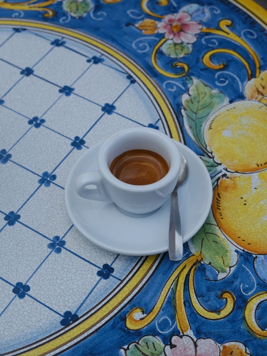 Uma xícara de espresso sobre uma mesa de cerâmica pintada, na Sicília
