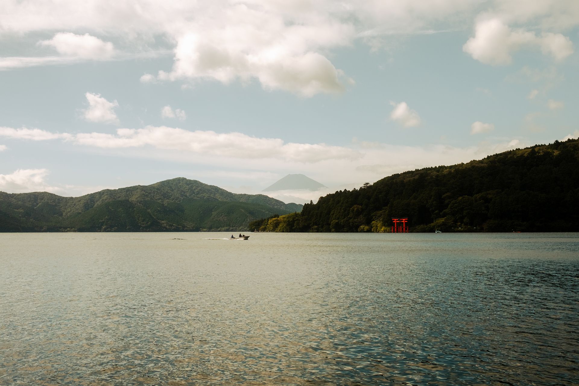 O portão torii vermelho dentro do Lago Ashi, em Hakone, com o Monte Fuji ao fundo