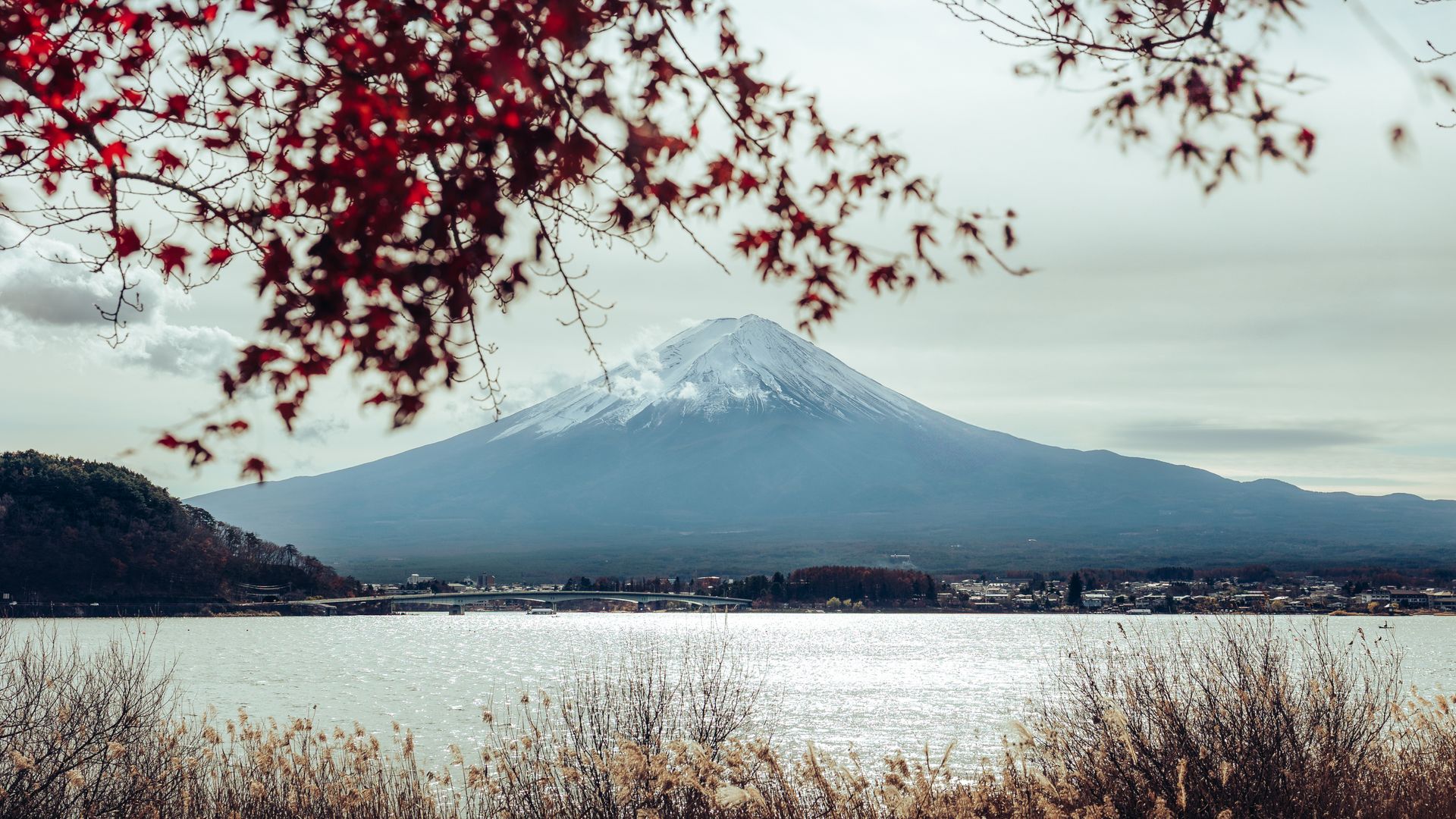 O Monte Fuji refletido no Lago Kawaguchiko, com folhas vermelhas de outono na margem