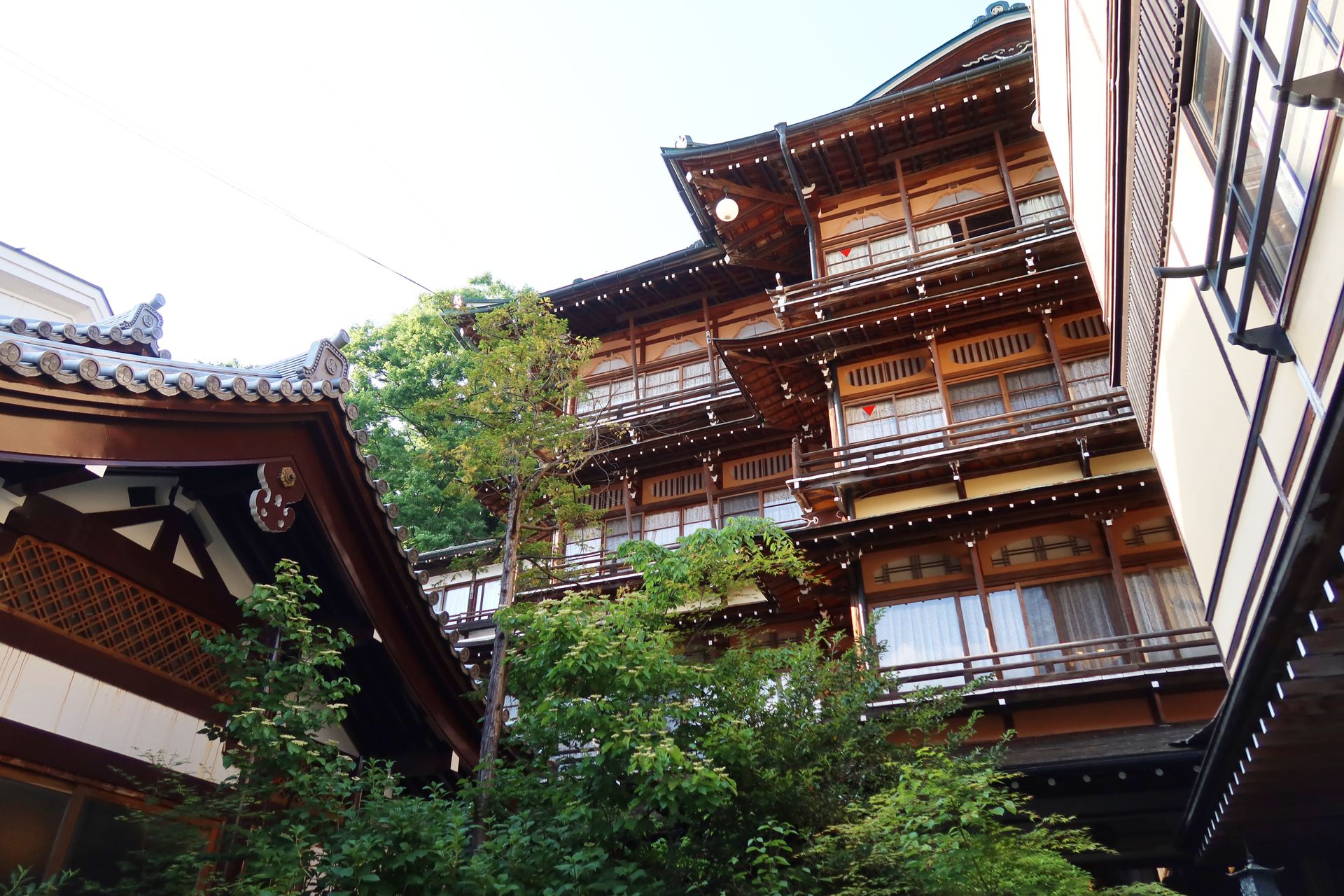 A fachada de madeira de um ryokan tradicional em Yamanouchi, Nagano, entre árvores