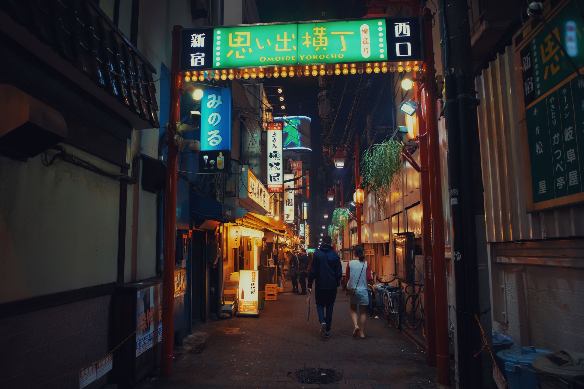 Pessoas caminham pelo beco Omoide Yokocho, em Shinjuku, à noite