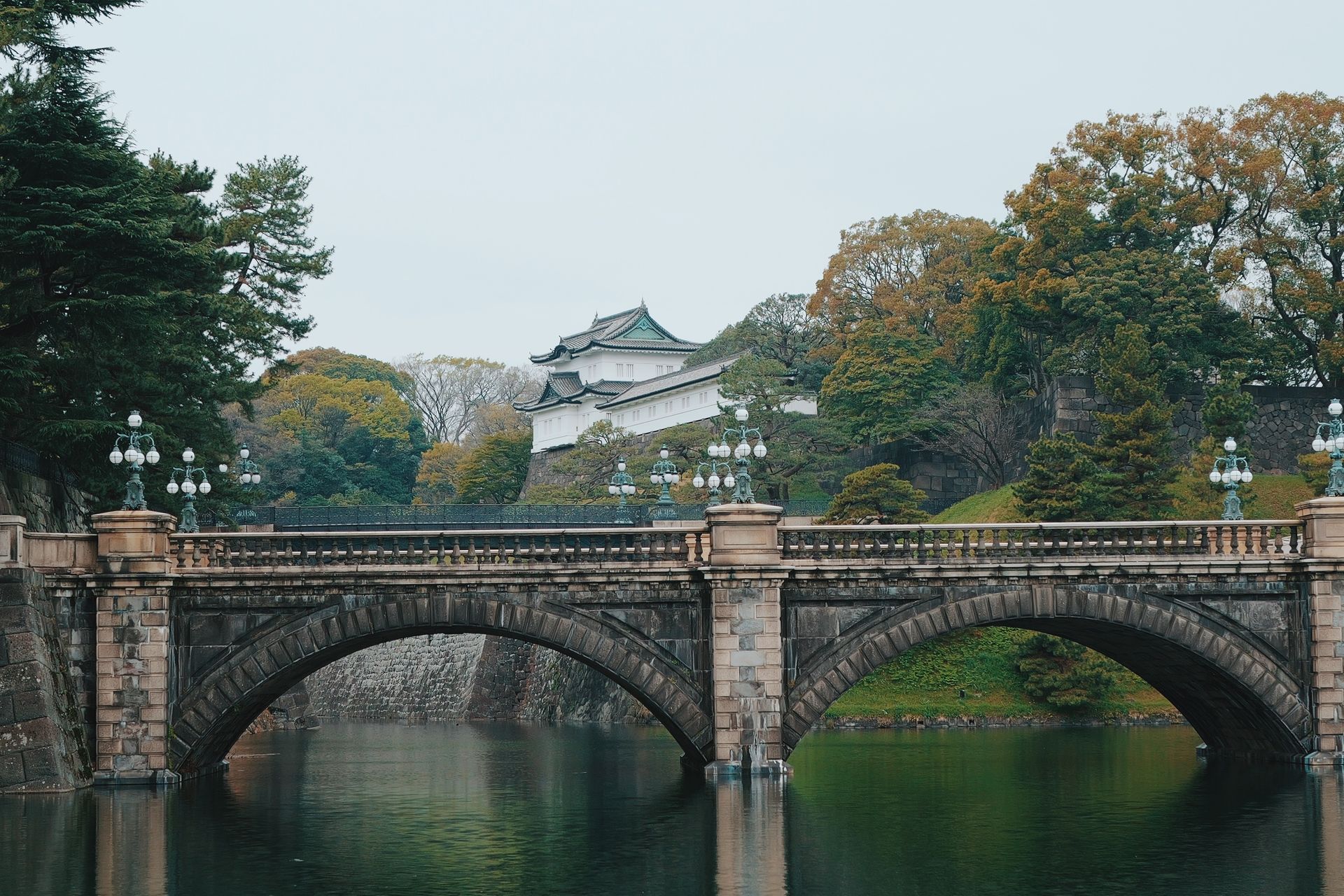 A ponte Nijubashi diante do Palácio Imperial de Tóquio, cercada de árvores