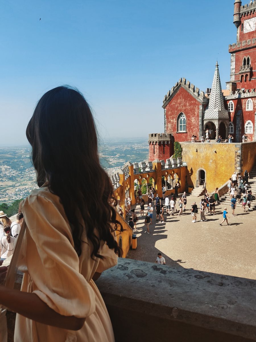 Mulher olhando as torres coloridas do Palácio da Pena, em Sintra